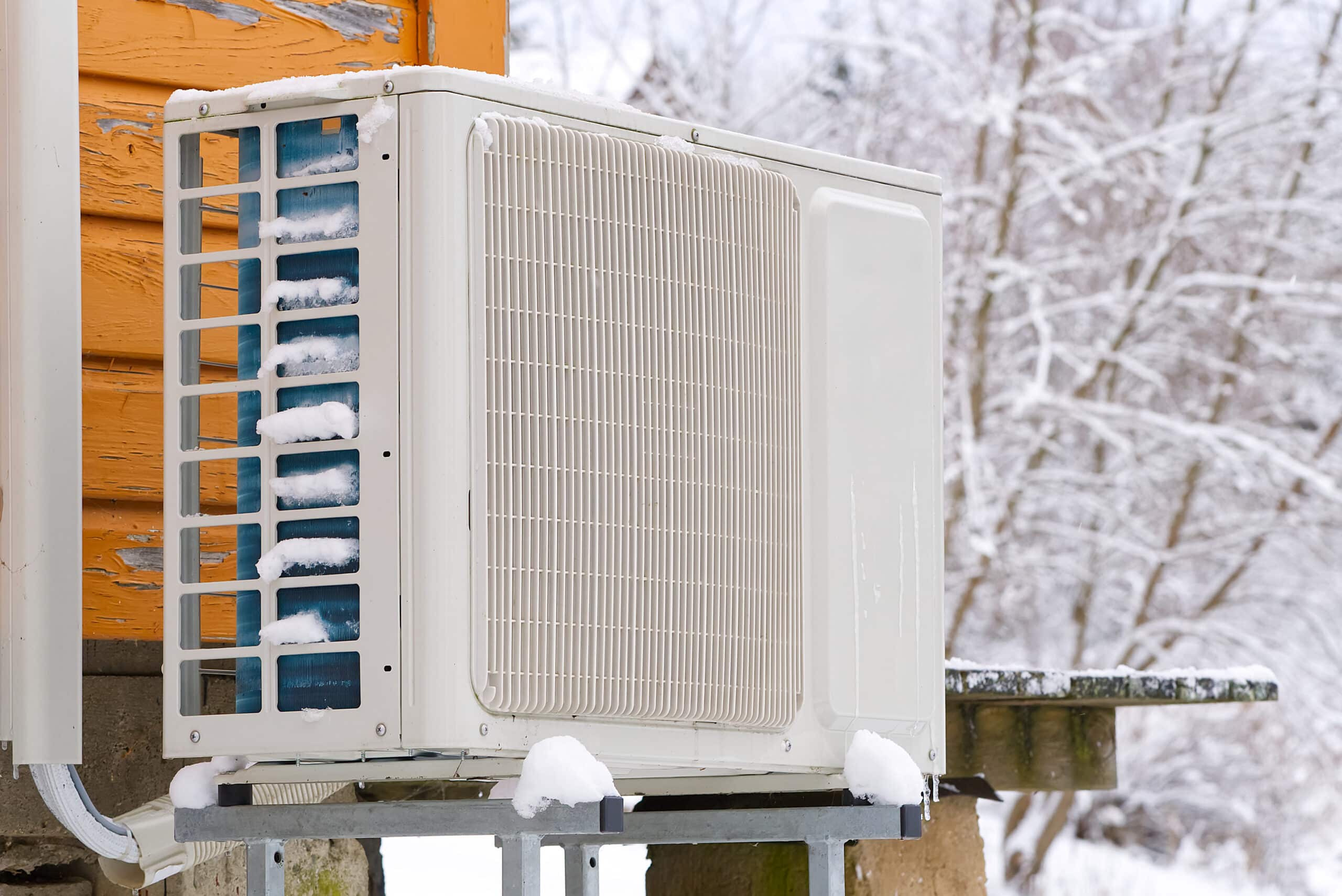 An outdoor condenser unit is covered in ice and snow 