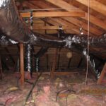 An attic scene displaying an intricate duct system, including multiple pipes and ducts installed in the ceiling.