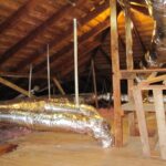 An attic with exposed ductwork and pipes