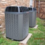 two air conditioners next to each other outside of a brick house