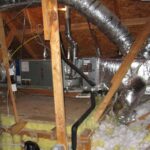 A furnace and ductwork installed in an attic, showcasing the heating system's components and layout.