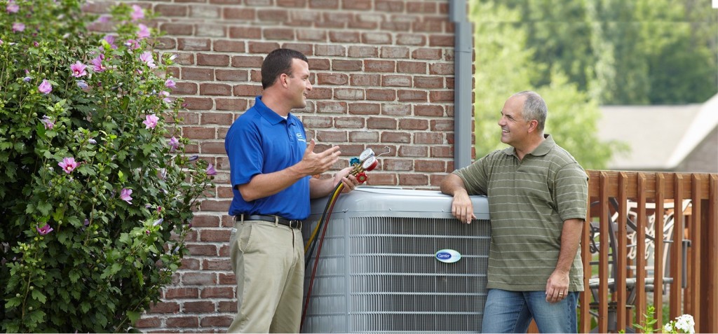 Customer and AC technician talking around the outdoor unit