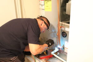 expert HVAC technician inspecting a furnace