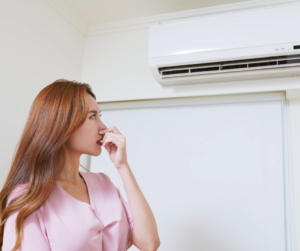 A woman closes her nose to prevent smelling bad smell in home
