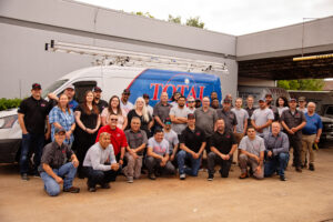 Total Air employees standing in front of total air van