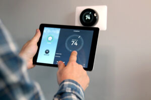 Ohio homeowner setting Wi-Fi thermostat with iPad on