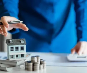 House model with stacked coins representing What Are the Hidden Costs of Skipping Furnace Maintenance